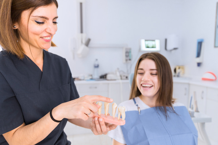 a dentist is showing how to get cosmetic dental treatments using CDCP benefits.