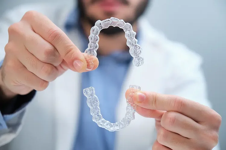 A real picture of a dentist shwoing invisalign in order to introduce the best Invisalign alternatives