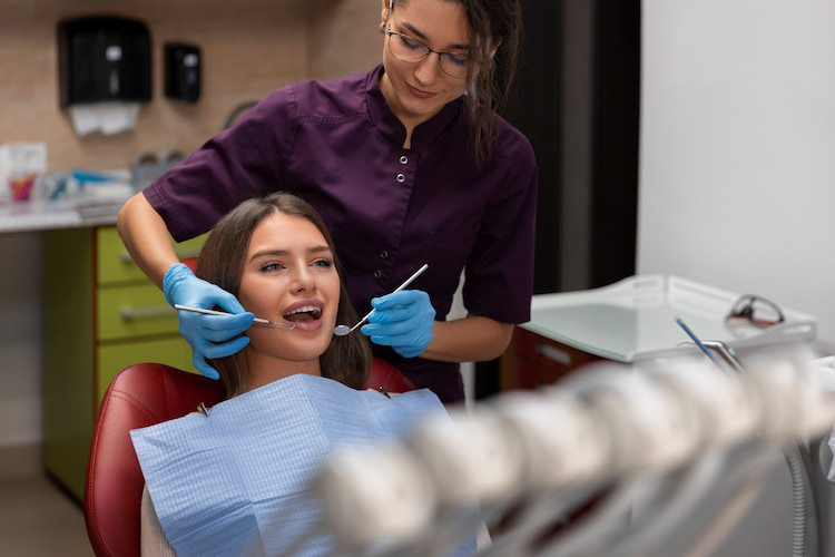 a cosmetic dentist is performing a treatment for a patient.