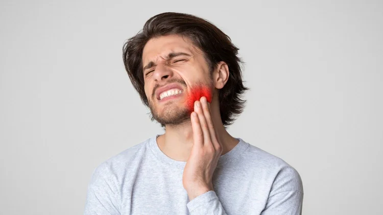 A picture of a man with tooth sensitivity after root canal therapy